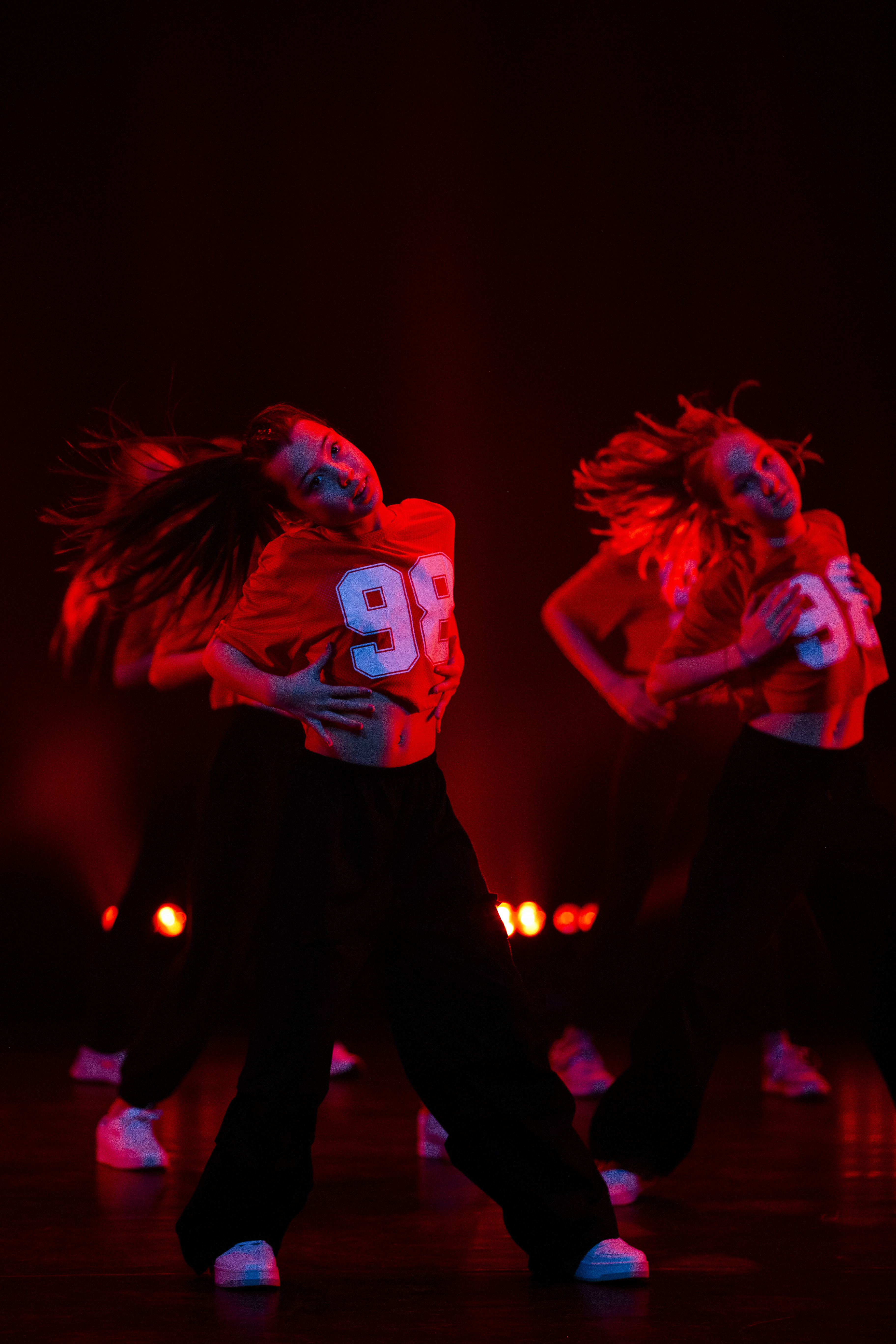 streetdance dancer urban style, dramatic warm lighting, high energy pose, editorial photography, film grain